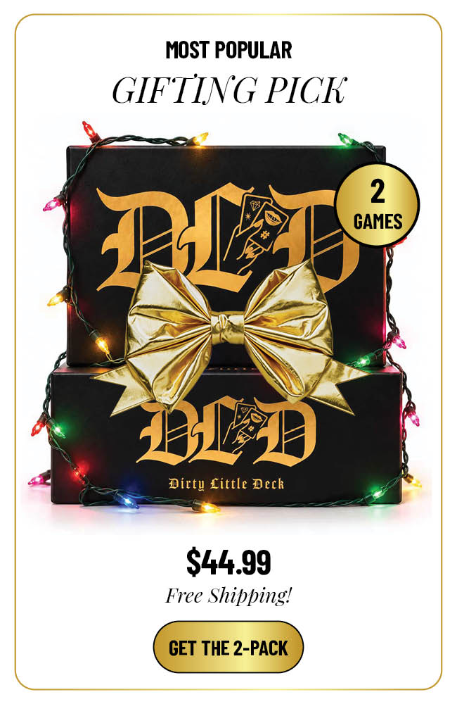 Two Dirty Little Deck game boxes wrapped in multicolor Christmas lights on a white background.